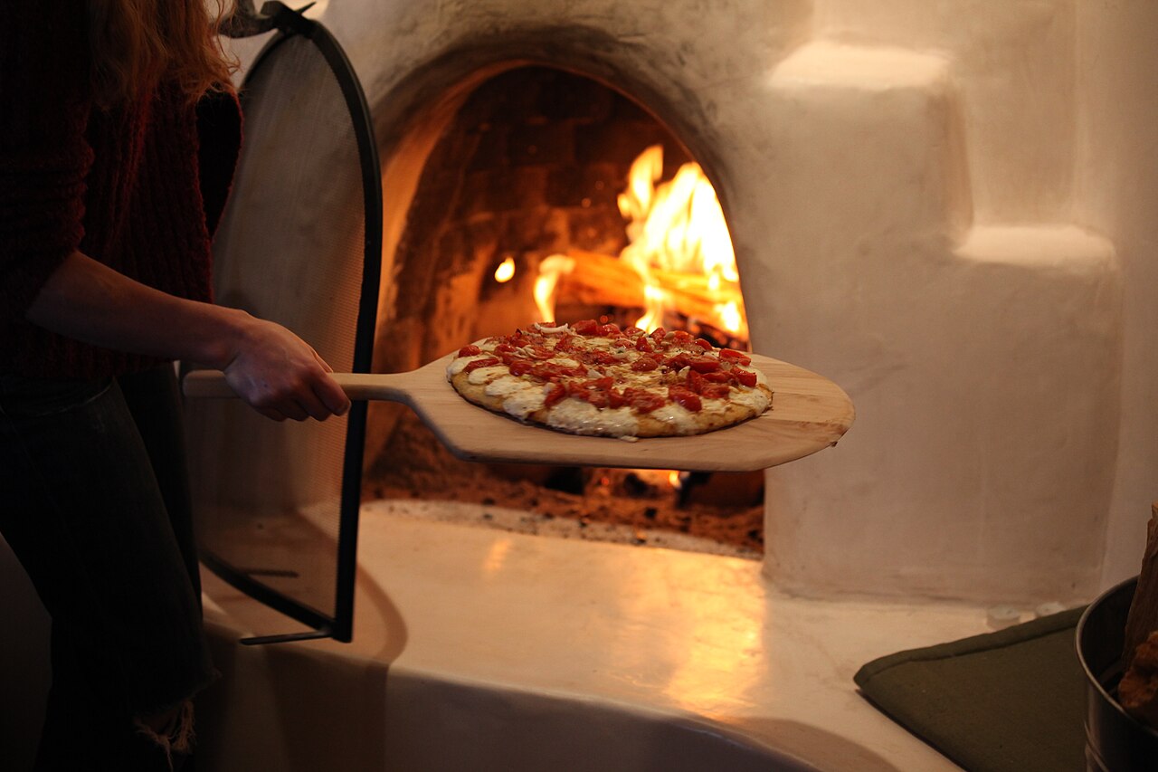 Pizza appena sfornata davanti al forno acceso